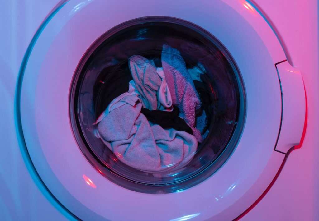 Washing clothes that has oil paint on it.